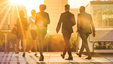Business colleagues walking in a city at sunset